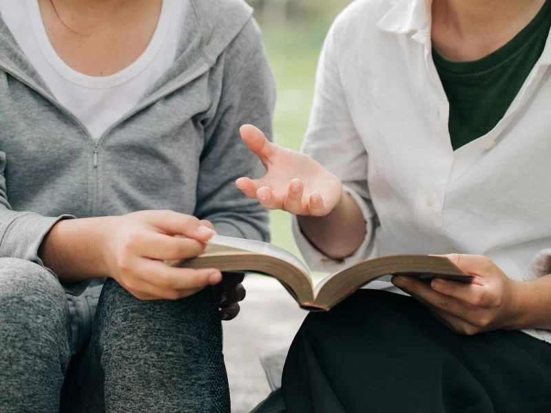 woman sharing the Bible with another woman