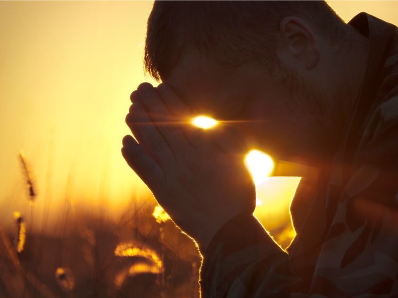 Soldier praying at sunrise