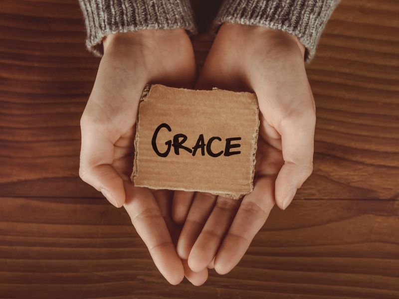 woman holding a sign with the word grace in her hands