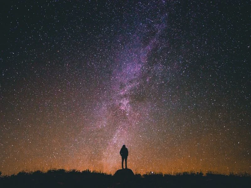 Person looking out at the vast star filled night sky