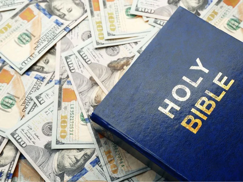 Holy Bible sitting on top of a $100 bills