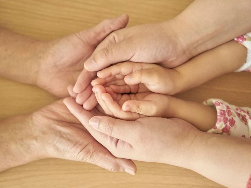 grandmother, mother and child holding hands