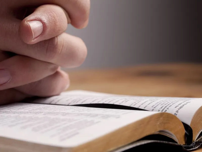 Man studying the Bible and praying